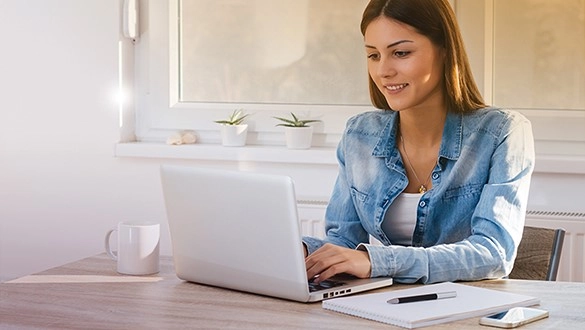 Moderne Frau arbeitet am Laptop, helles Büro, produktive Atmosphäre.