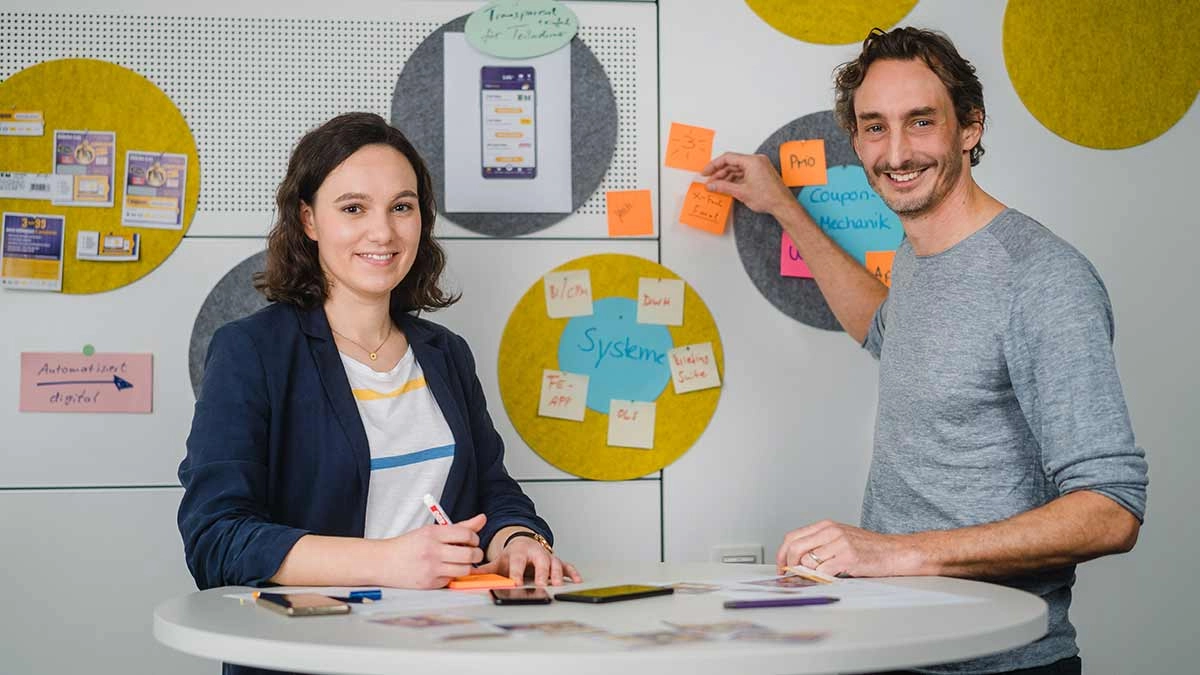 Innovatives Teamwork am runden Tisch: Kreative Ideenfindung mit Post-its und Technologie.