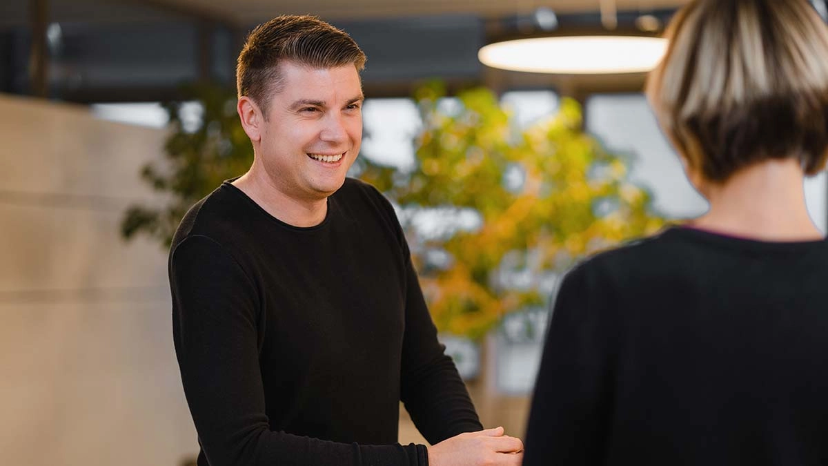 Professionelles Gespräch in moderner Büroumgebung, einladend und dynamisch.