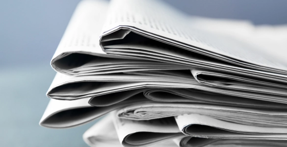Stapel frischer Zeitungen, bereit für aktuelle Nachrichten und spannende Lektüre.
