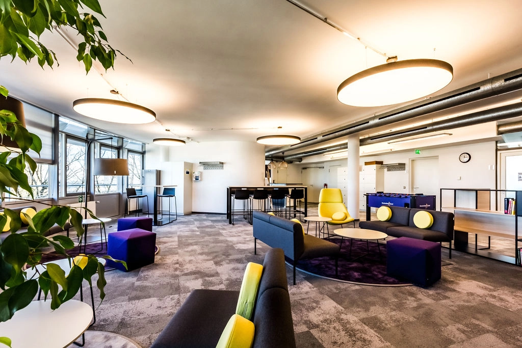 Moderner, einladender Büroraum mit stilvollem Design und flexiblen Arbeitsbereichen.