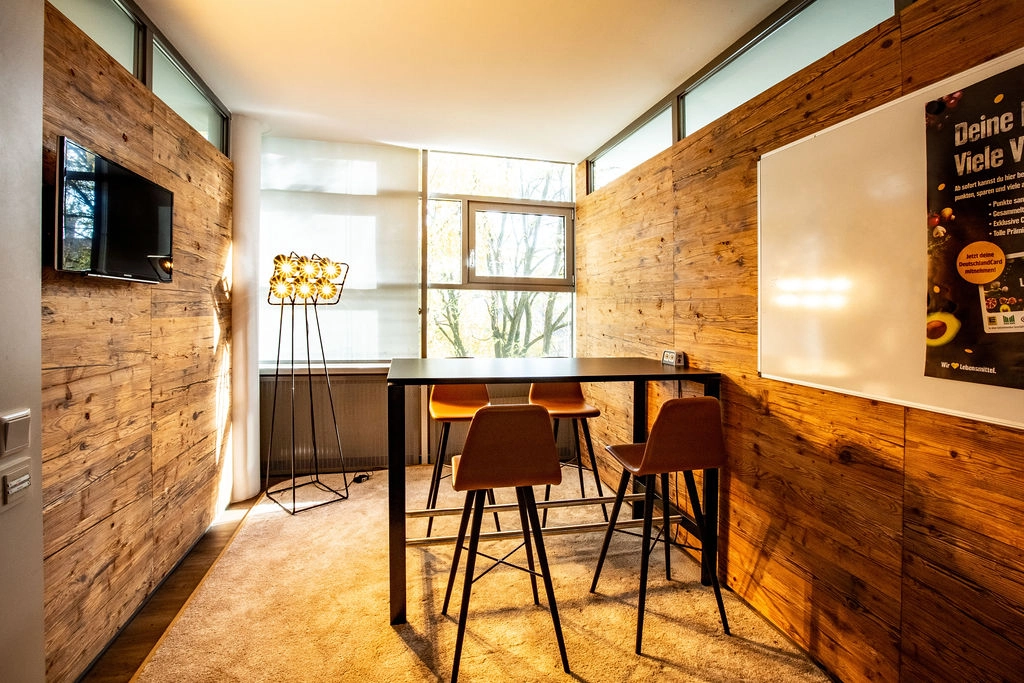 Moderner Besprechungsraum mit Holzwänden und stilvoller Beleuchtung.